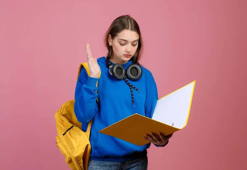 pretty-schoolgirl-standing-reading-raising-hand-answering